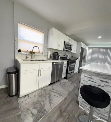 a kitchen with stainless steel appliances granite countertop a stove a sink and a microwave