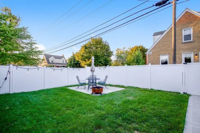 a backyard of a house with table and chairs
