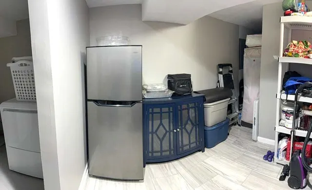 a walk in closet with wooden floor