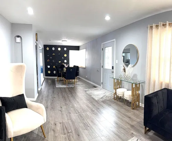 a living room with furniture and a wooden floor