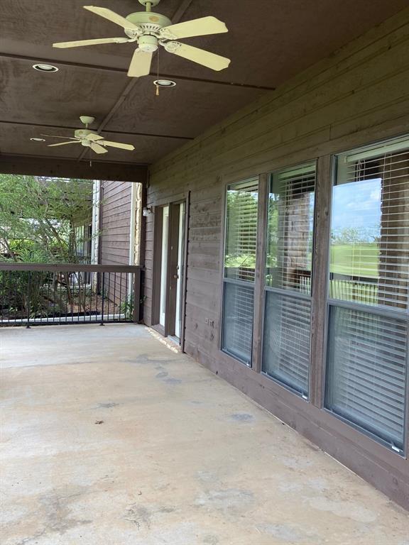 27101 Meadowmore Court Whitney, TX 76692 - Photo 23 of 32 Side view of back patio showing two ceiling fans and windows in back of living area.