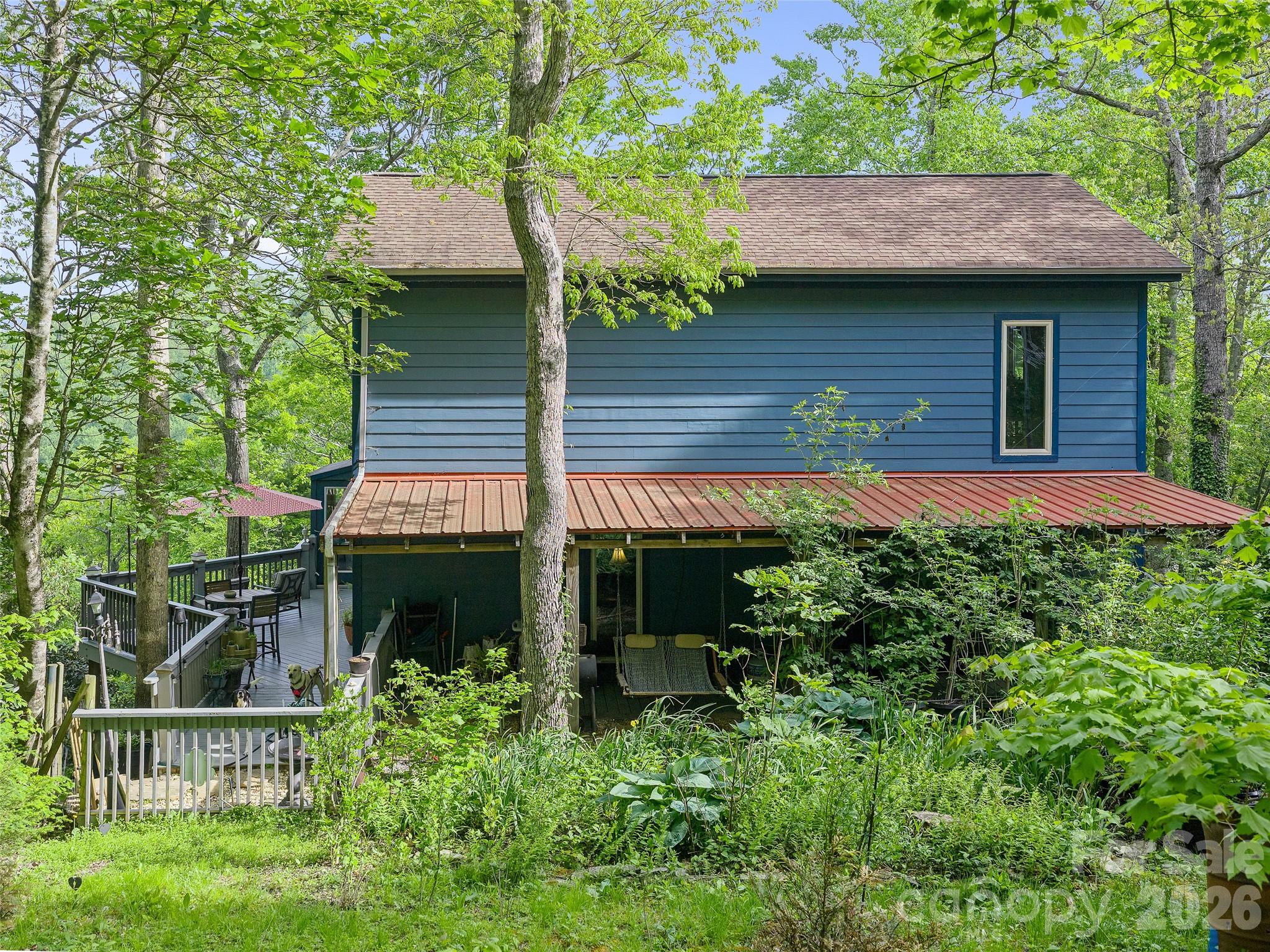228 Continental Divide Road Spruce Pine, NC 28777 - Photo 28 of 48 a view of a house with a yard plants and large tree