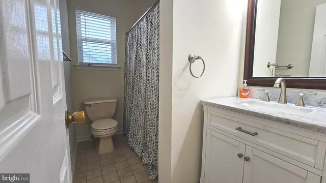 a bathroom with a toilet sink vanity and mirror