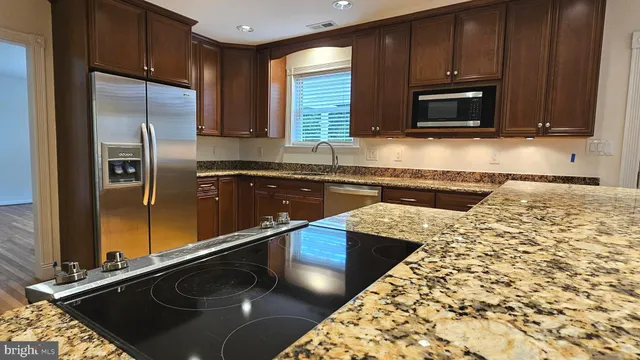 a kitchen with stainless steel appliances granite countertop a sink stove and microwave