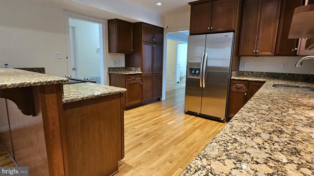 a kitchen with stainless steel appliances granite countertop a refrigerator and a stove