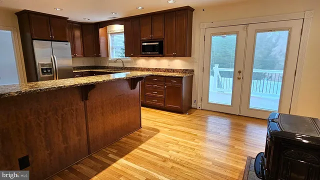 a kitchen with stainless steel appliances granite countertop a refrigerator and a stove