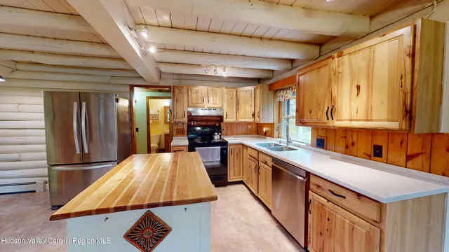 a kitchen with kitchen island granite countertop a sink a counter top space and stainless steel appliances