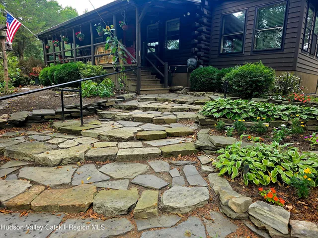 a backyard of a house with lots of green space and fountain
