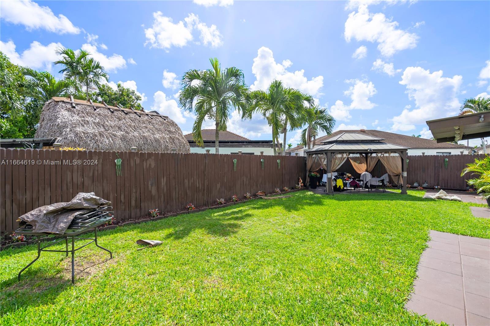 15831 Southwest 143rd Court Miami, FL 33177 - Photo 7 of 27 a view of a backyard with table and chairs potted plants and wooden fence