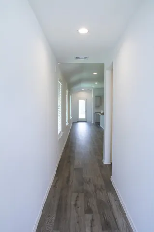 a view of a hallway with wooden floor