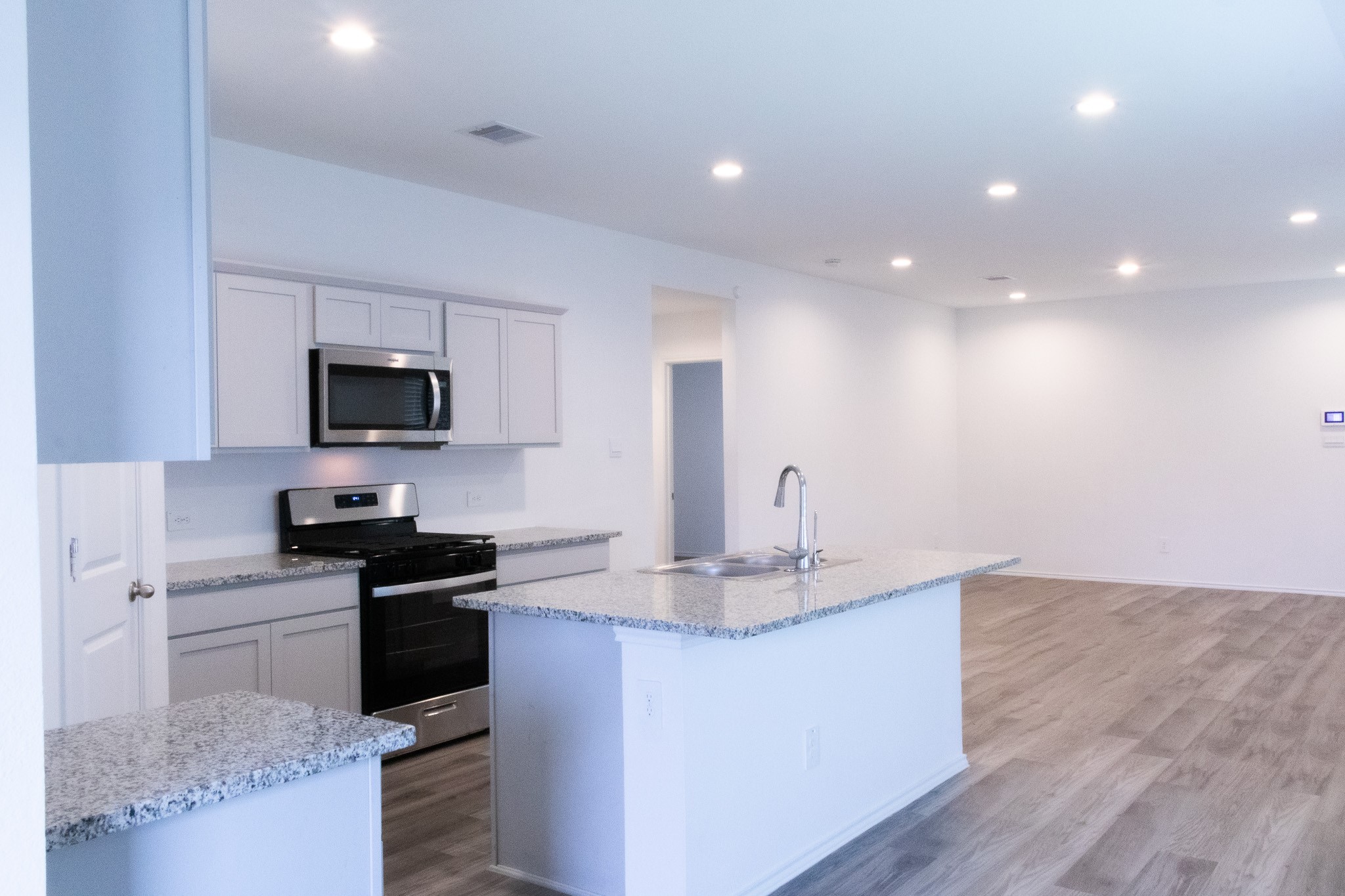 5342 Pinecliff Grove Court Spring, TX 77373 - Photo 5 of 27 a kitchen with kitchen island granite countertop a sink and microwave