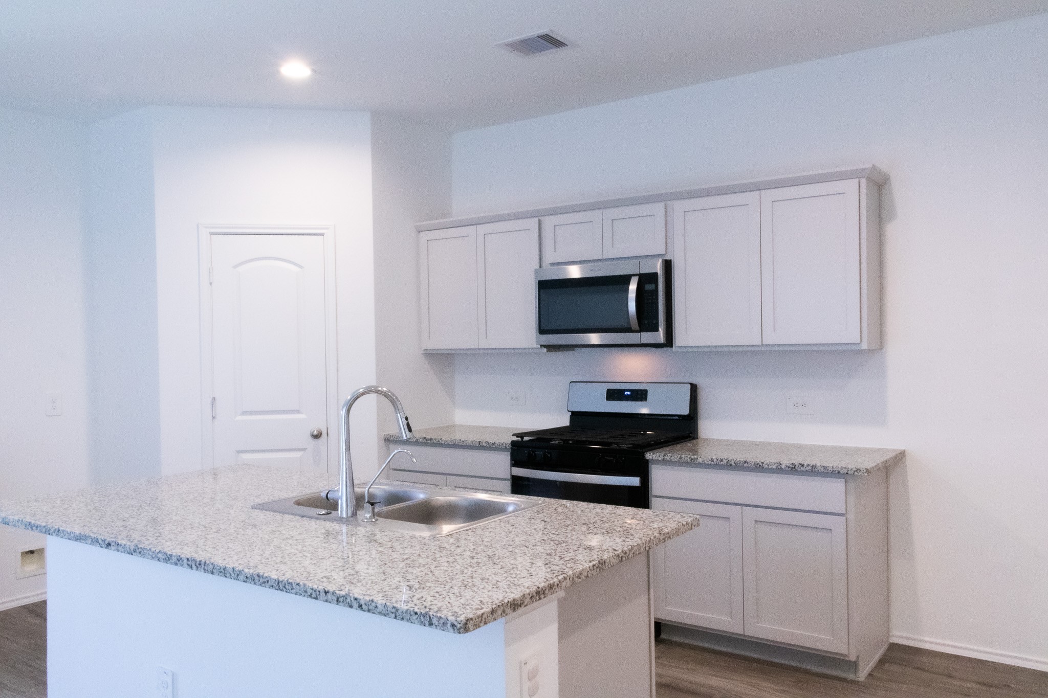 5342 Pinecliff Grove Court Spring, TX 77373 - Photo 9 of 27 a kitchen with granite countertop white cabinets and black appliances
