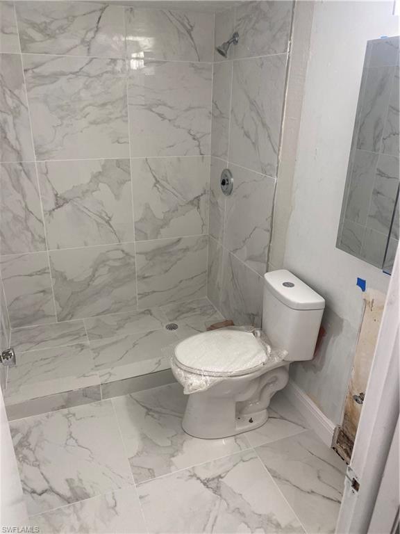 830 Wiggins Pass Road, Unit 10 Naples, FL 34110 - Photo 3 of 6 Bathroom featuring a tile shower and toilet