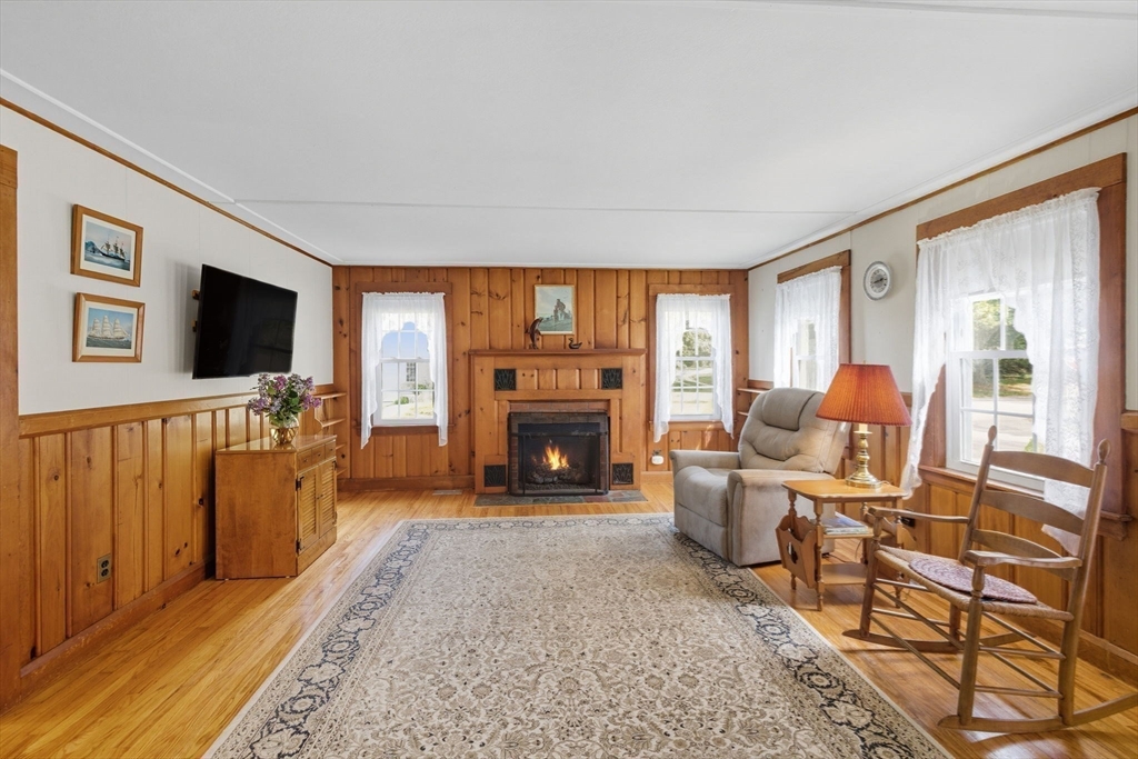 6 Defiance Lane Orleans, MA 02653 - Photo 5 of 27 a living room with furniture a flat screen tv and a fireplace