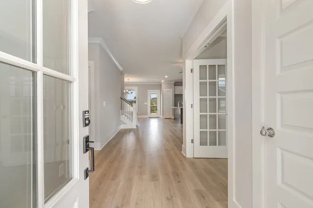 a view of a hallway with wooden floor and staircase