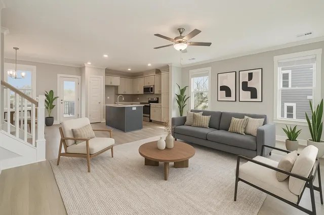 a living room with furniture and a view of kitchen