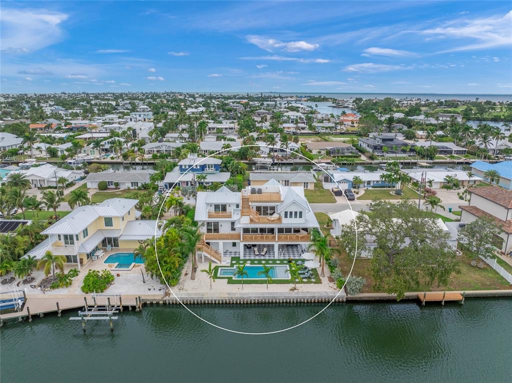 an aerial view of residential houses with outdoor space and lake view