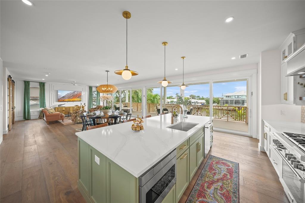 525 68th Street Holmes Beach, FL 34217 - Photo 13 of 52 a view of a kitchen with kitchen island a large counter top stainless steel appliances and windows