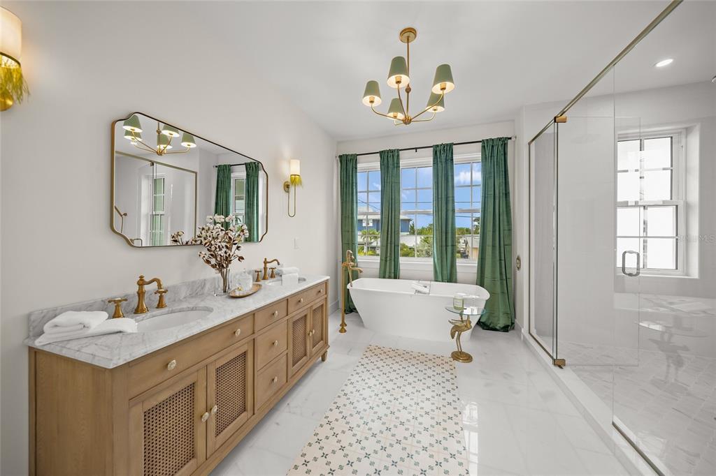 525 68th Street Holmes Beach, FL 34217 - Photo 22 of 52 a spacious bathroom with a double vanity sink mirror and bathtub