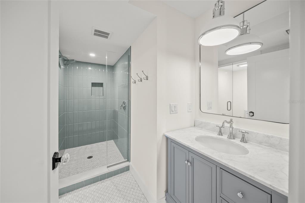 525 68th Street Holmes Beach, FL 34217 - Photo 37 of 52 a bathroom with a shower sink vanity granite and mirror