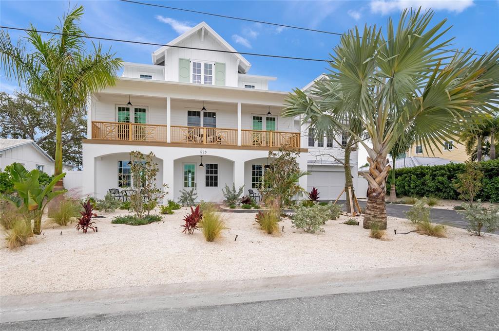 525 68th Street Holmes Beach, FL 34217 - Photo 7 of 52 a front view of a house with a yard and potted plants