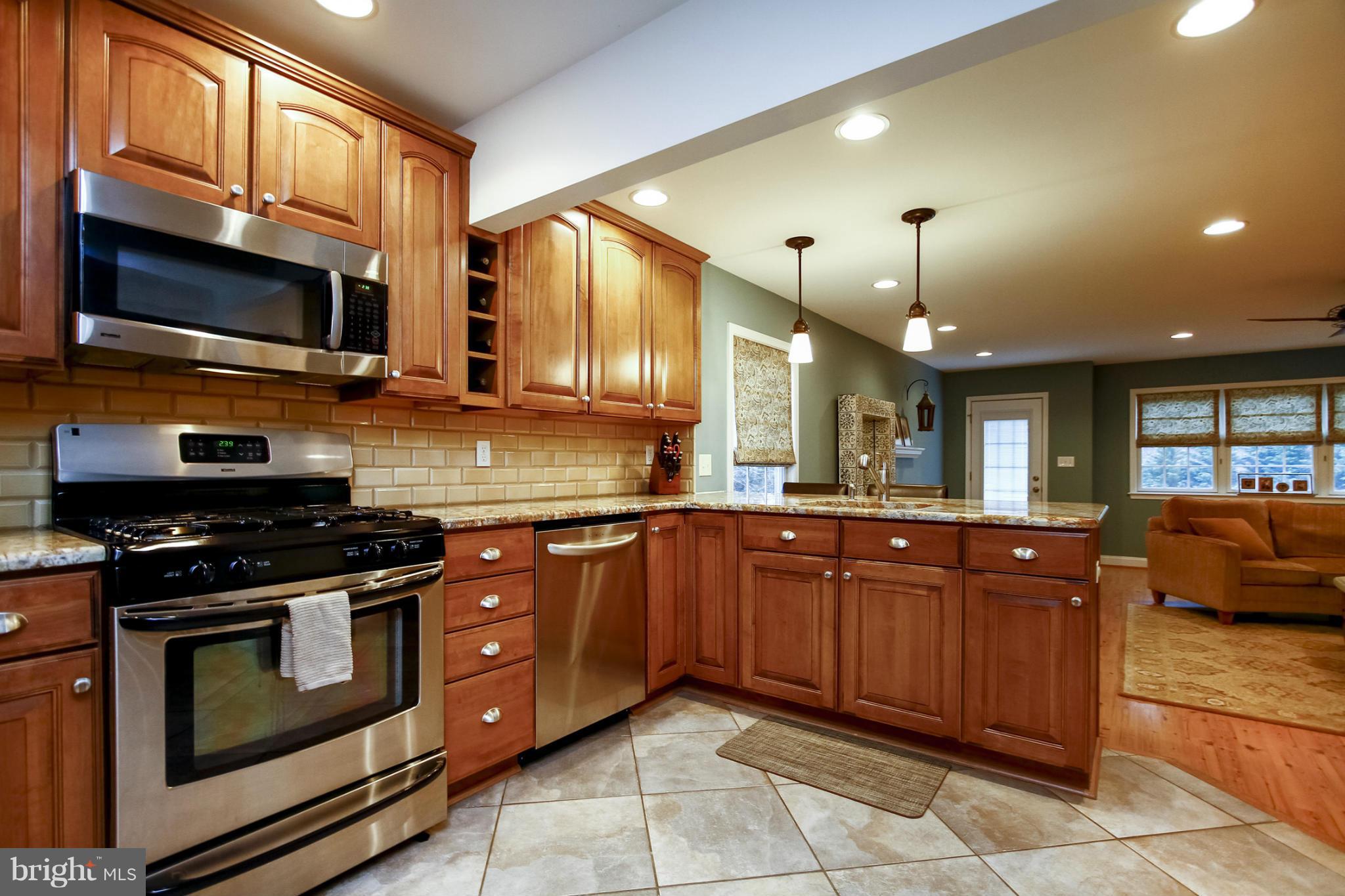 929 Litchfield Road Baltimore, MD 21239 - Photo 3 of 29 a kitchen with stainless steel appliances granite countertop wooden cabinets a stove a sink and a microwave