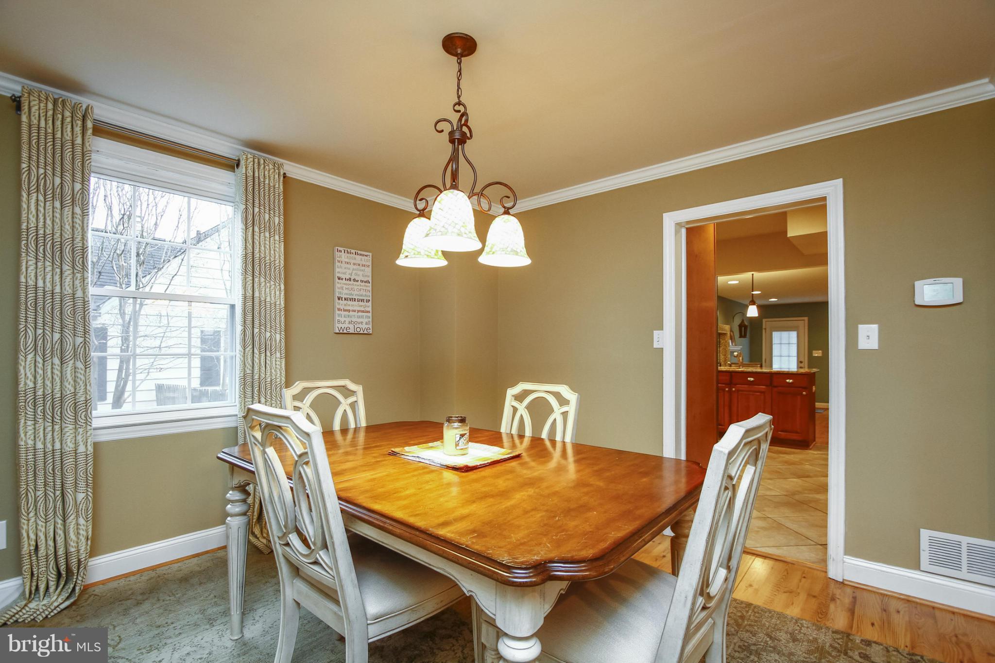 929 Litchfield Road Baltimore, MD 21239 - Photo 5 of 29 a dining room with wooden floor a chandelier a wooden table and chairs