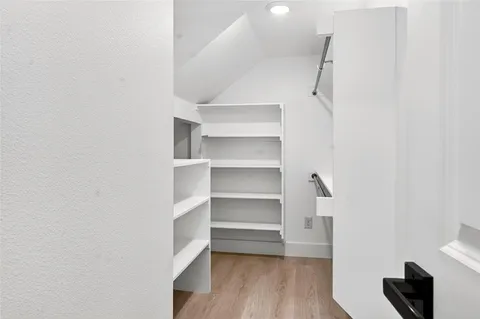 a view of walk in closet with empty racks