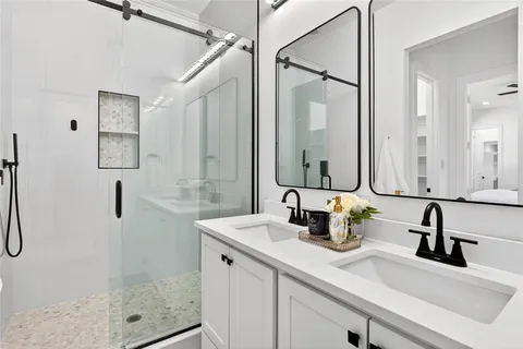 a bathroom with a shower sink and mirror