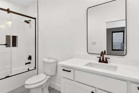 a bathroom with a sink a toilet a mirror and shower