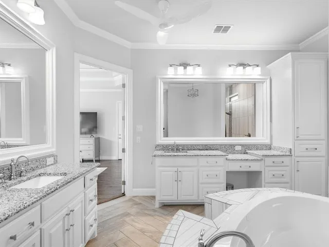 a bathroom with a granite countertop tub sink and mirror