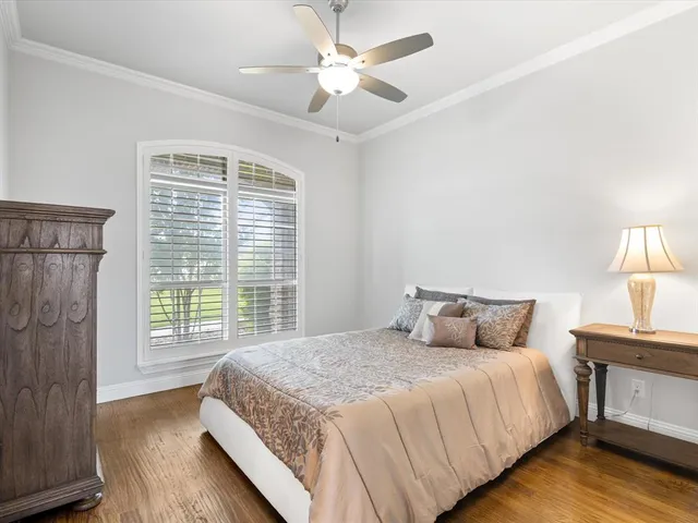 an empty room with wooden floor chandelier fan and windows