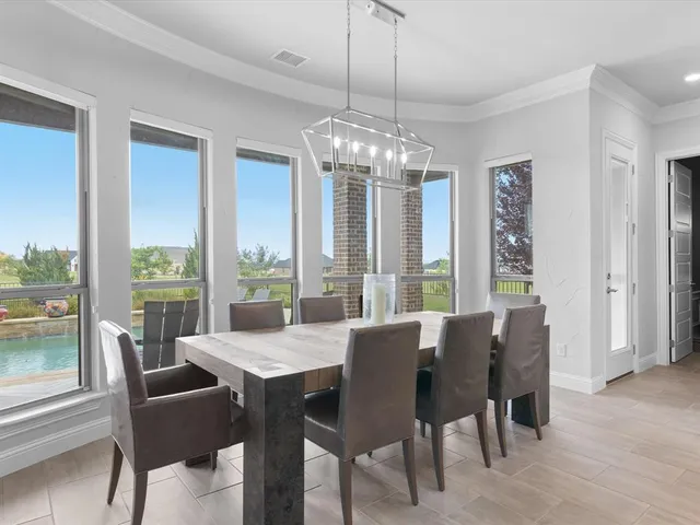 a kitchen with stainless steel appliances kitchen island granite countertop a table chairs sink and cabinets