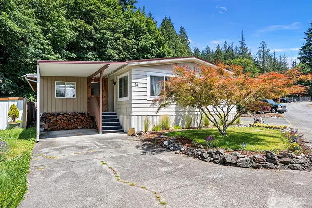 a view of a house with a yard and potted plants
