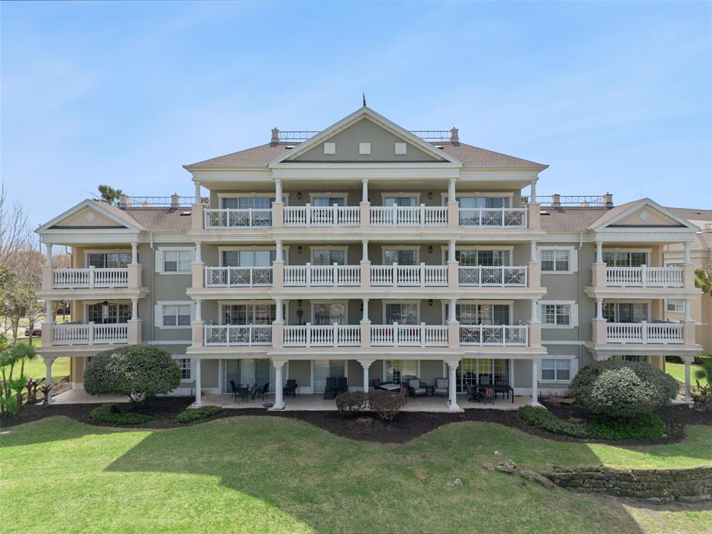 1352 Centre Ct Ridge Drive, Unit 302 Reunion, FL 34747 - Photo 17 of 42 a front view of a building with garden space and outdoor seating
