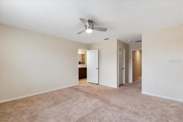 a view of an empty room and chandelier fan