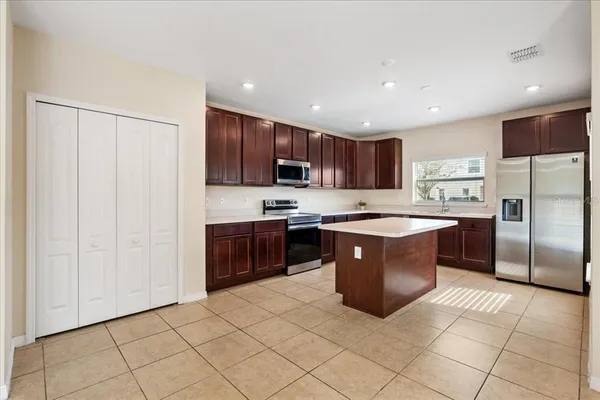 a large kitchen with stainless steel appliances granite countertop a stove a sink a microwave and a refrigerator