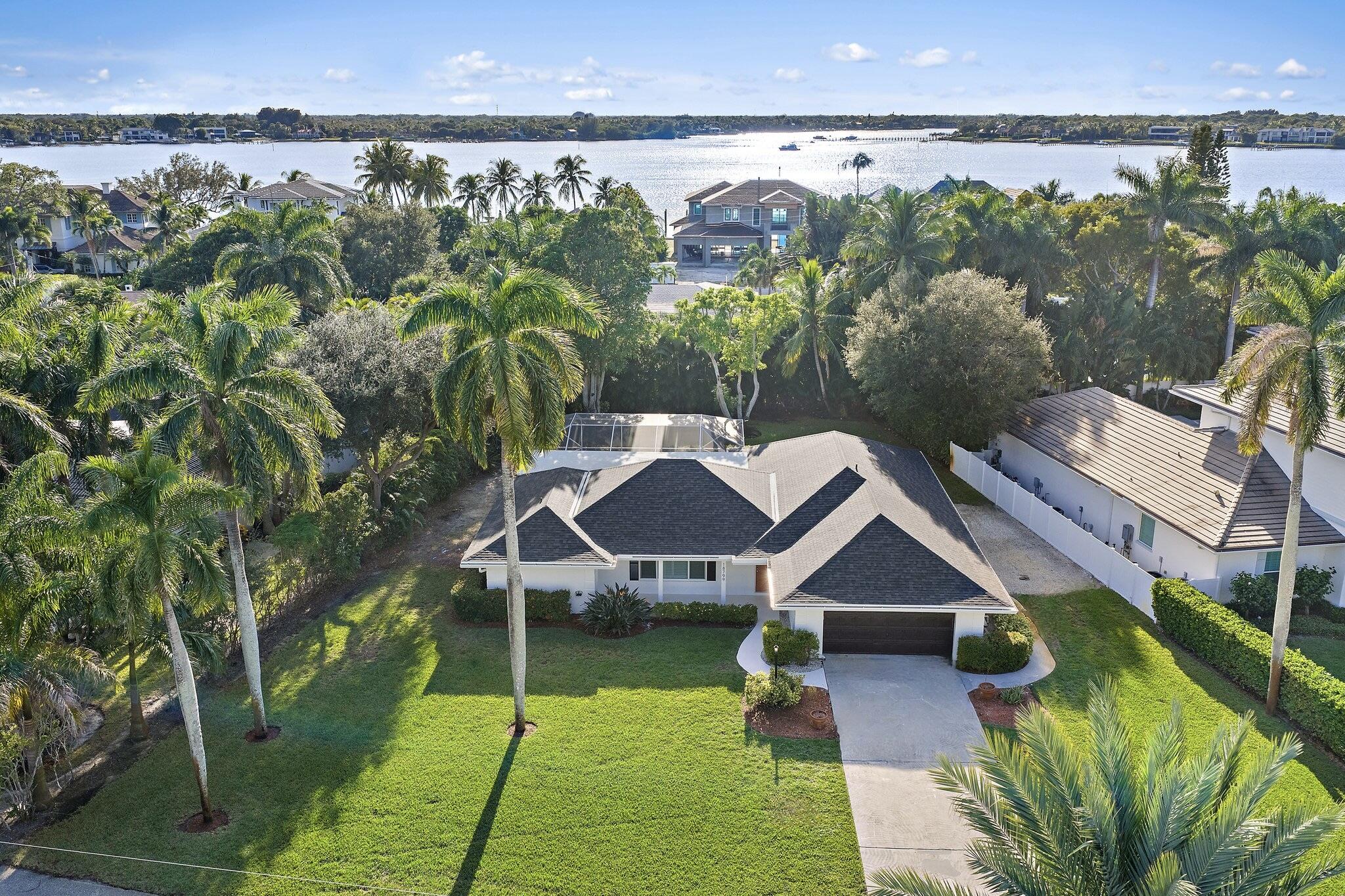 18799 Rio Vista Drive Jupiter, FL 33469 - Photo 2 of 58 a view of a house with a yard and potted plants