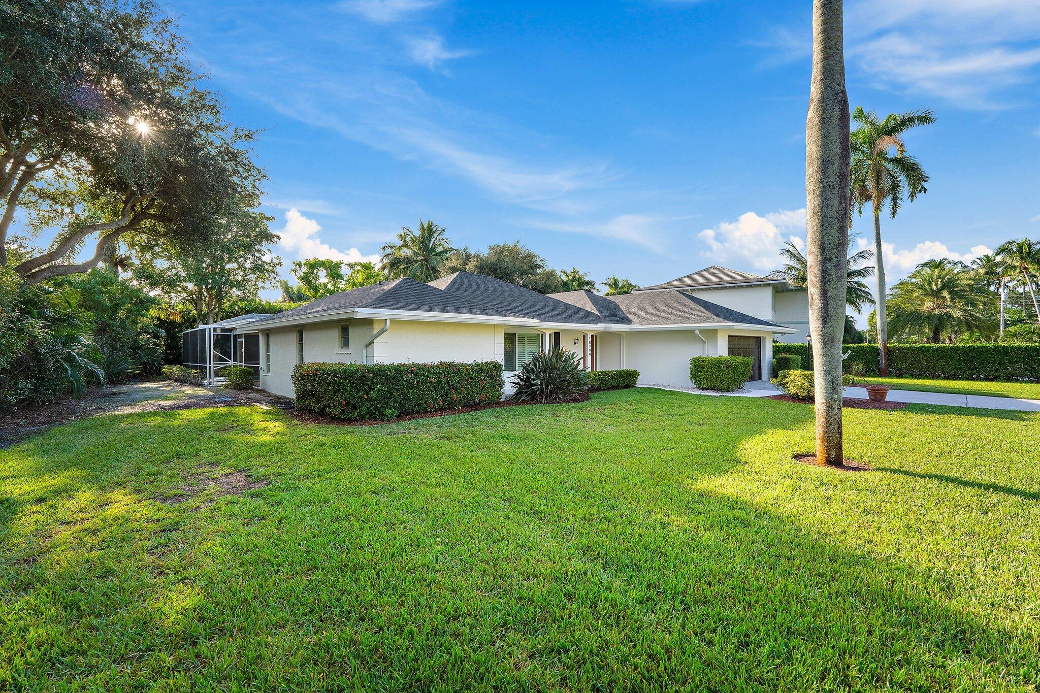 18799 Rio Vista Drive Jupiter, FL 33469 - Photo 48 of 58 a front view of a house with a yard and garage