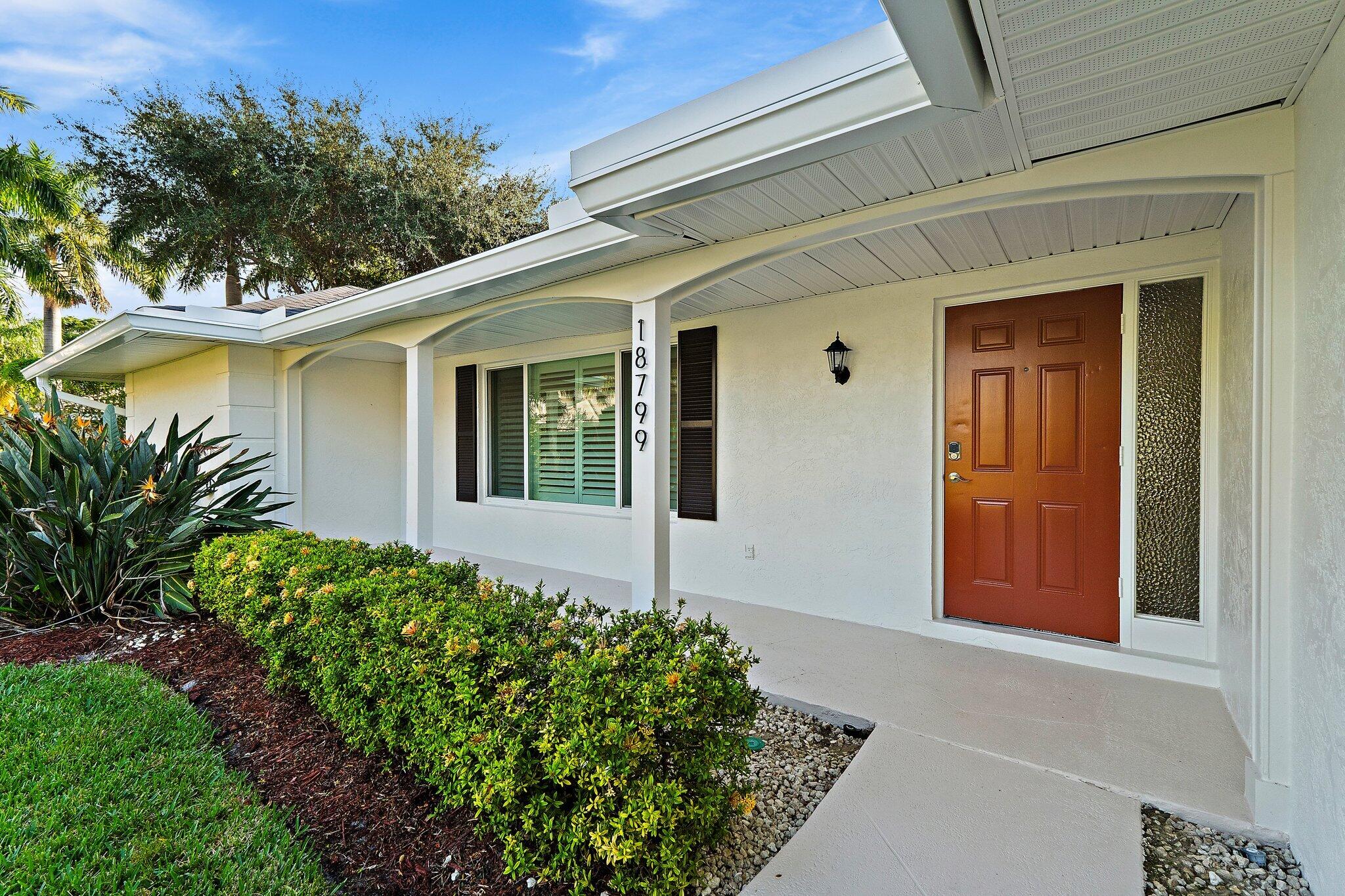18799 Rio Vista Drive Jupiter, FL 33469 - Photo 8 of 58 front view of a house with a yard