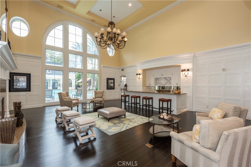 3261 Watermarke Place Irvine, CA 92612 - Photo 28 of 31 a living room with furniture a chandelier and a dining table with wooden floor