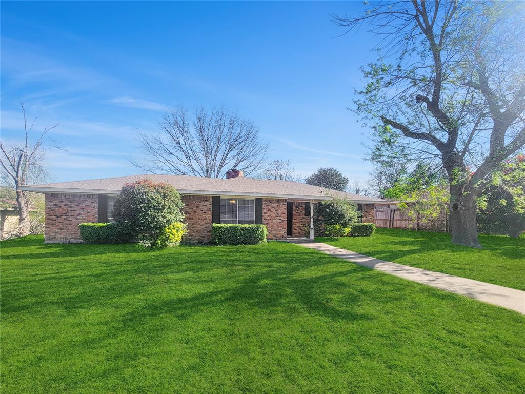 Single story home with brick siding, a front lawn, fence, and a chimney