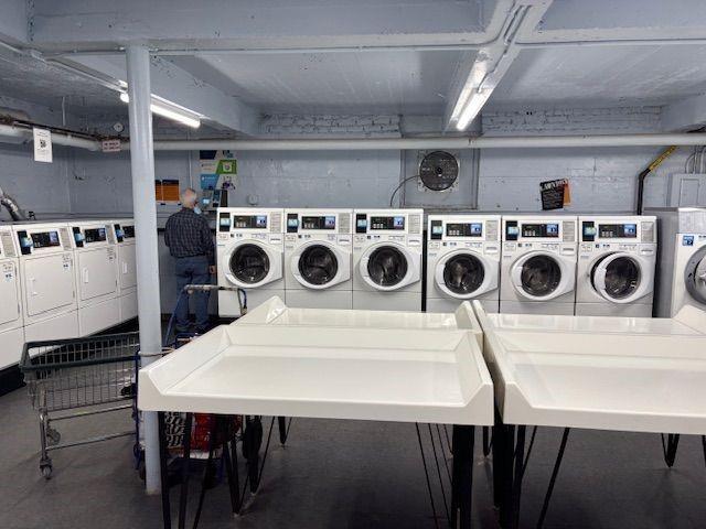 601 79th Street, Unit C20 Brooklyn, NY 11209 - Photo 12 of 13 a utility room with stainless steel appliances wooden floor a white stove a sink and a refrigerator