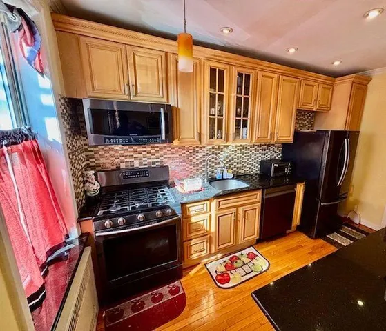 a kitchen with stainless steel appliances granite countertop a stove a sink and a microwave