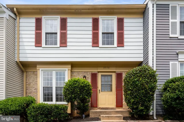 a view of a brick building next to a yard with big trees
