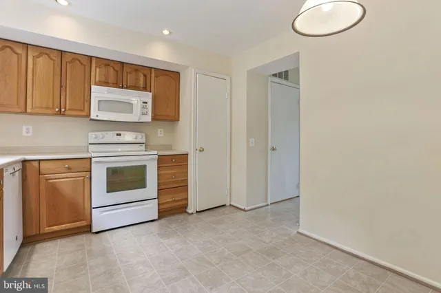 a kitchen with white cabinets and white appliances