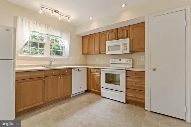 a kitchen with white cabinets and white appliances