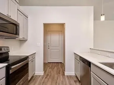 a kitchen with stainless steel appliances a stove microwave and sink