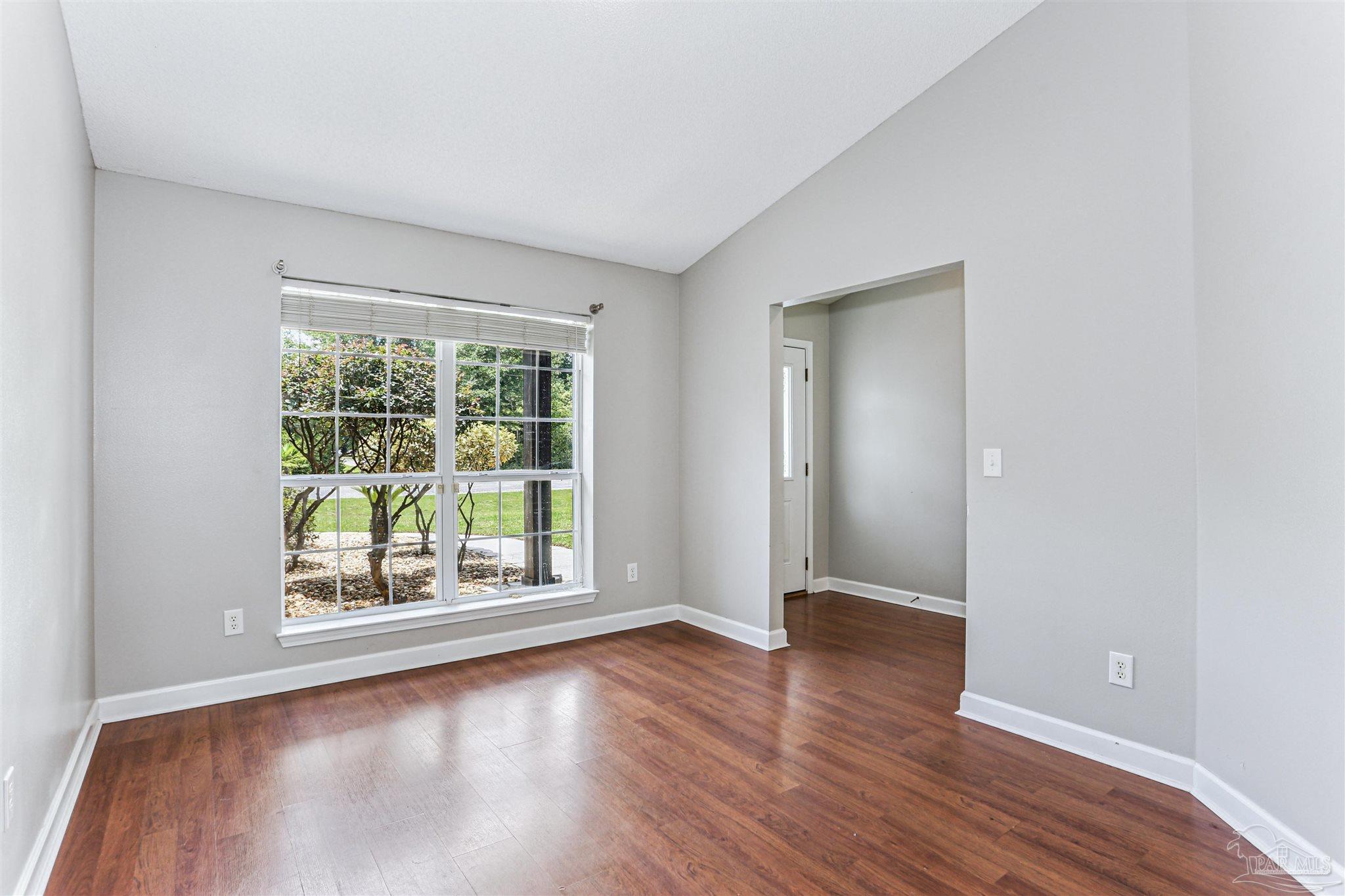 1062 Joaquin Road Pensacola, FL 32506 - Photo 13 of 42 an empty room with wooden floor and windows