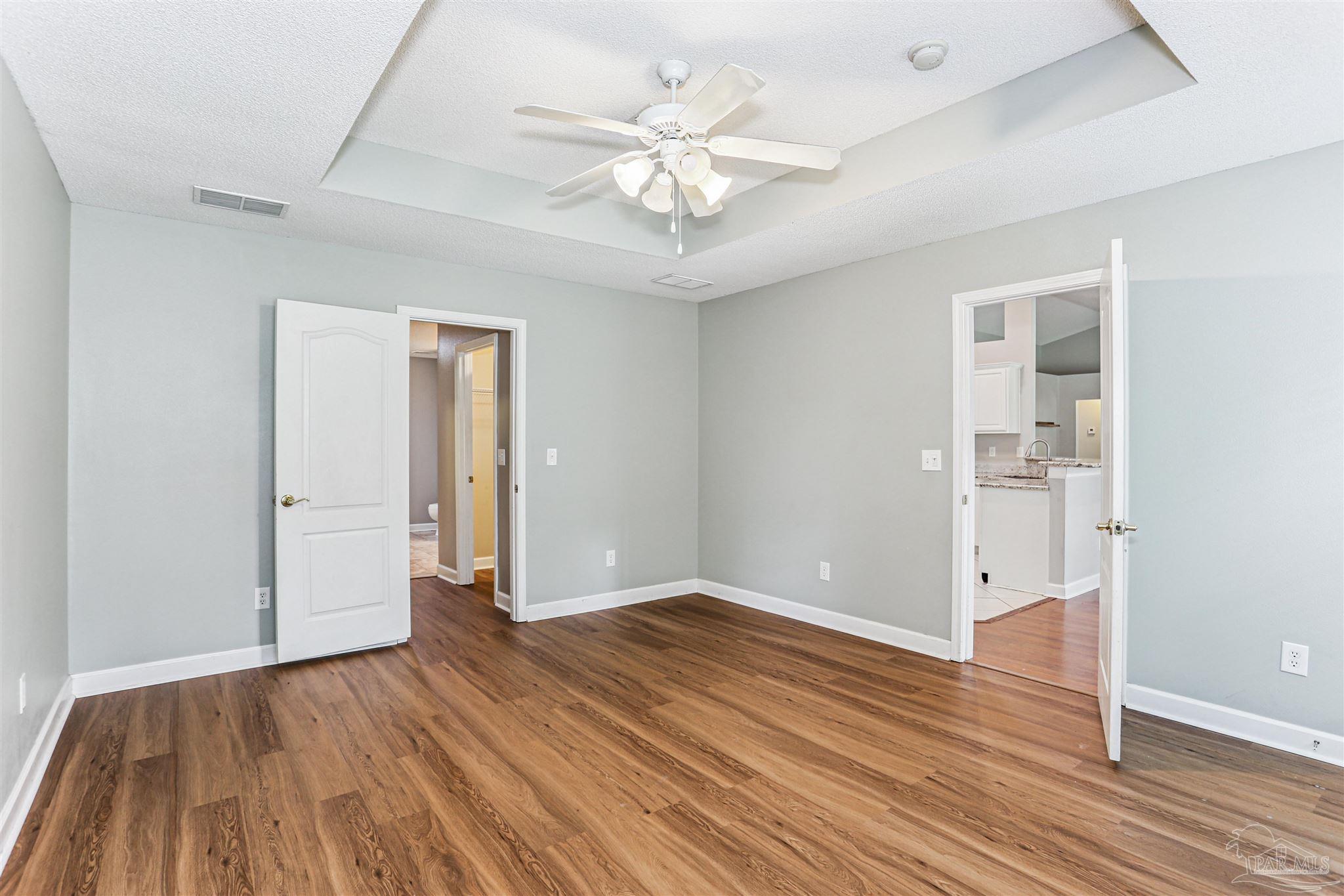 1062 Joaquin Road Pensacola, FL 32506 - Photo 21 of 42 an empty room with wooden floor and a ceiling fan